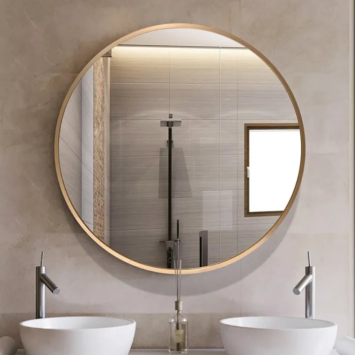 Round bathroom mirror with wooden frame reflecting a tiled wall and fixtures.